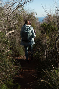 Woman contemplates the landscapes of the garraf natural park while walking the paths of a mountain.