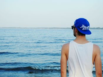 Rear view of man standing in front of sea