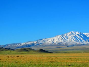 Scenic view of snow covered mountains against clear sky