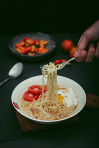 Cropped hand fork noodle in the bowl