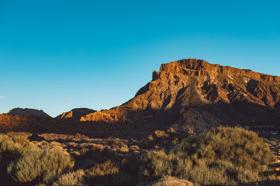 Scenic view of mountains against clear blue sky