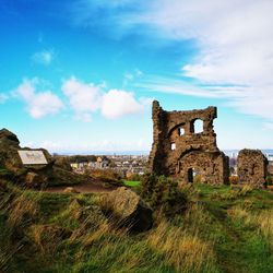 Old ruins on land against blue sky
