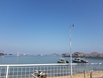 Sailboats in sea against clear blue sky