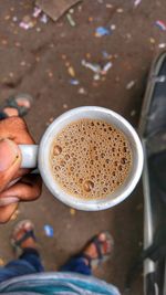 Low section of man holding tea cup