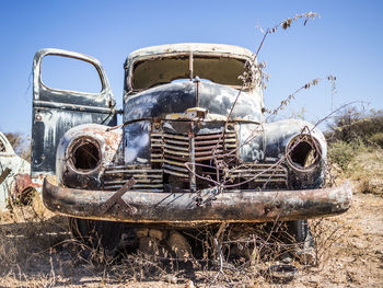 Abandoned cars against sky