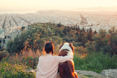 Rear view of people looking at cityscape against sky