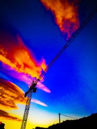 Low angle view of silhouette electricity pylon against sky during sunset