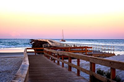 Pier over sea against sky during sunset