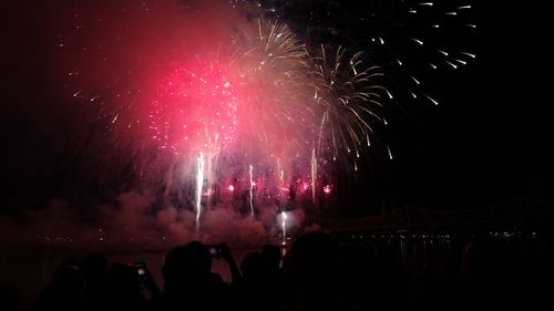 People watching firework display at night