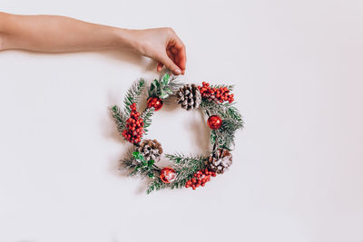 Wreath frame from pine and christmas decor in female hands on a light background. eelegant style