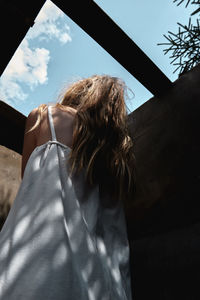 Girl with hope looks at the sky in a house without a roof