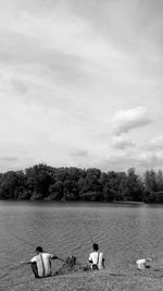 Swans swimming in lake against sky