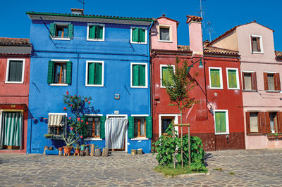 View of colorful houses on sunny day in burano, a gracious little town full of canals in italy.