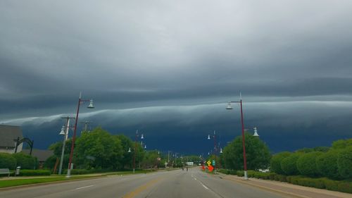 Road by trees against sky