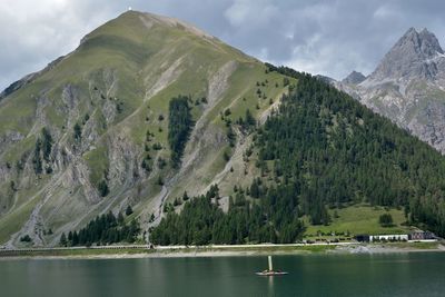 Scenic view of lake by mountains against sky