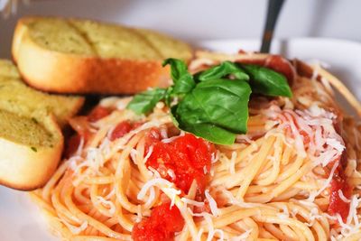 Close-up of spaghetti and toasted bread in plate