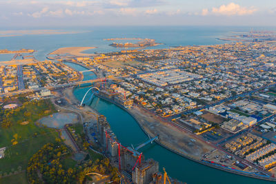 High angle view of cityscape by sea against sky