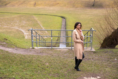 Full length of woman standing by railing