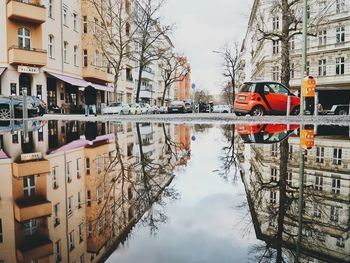 Reflection of buildings and car on canal