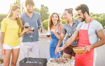 Friends enjoying meat and wine at social gathering