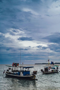 Boats moored in sea against sky