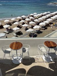 High angle view of empty chairs and table at beach