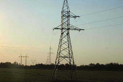 Low angle view of electricity pylon on field against sky