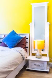 Table and yellow bed in bedroom at home