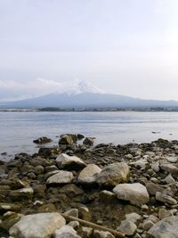 Rocks on sea shore against sky