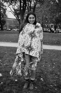 Full length of beautiful woman wrapped in shawl while standing at park