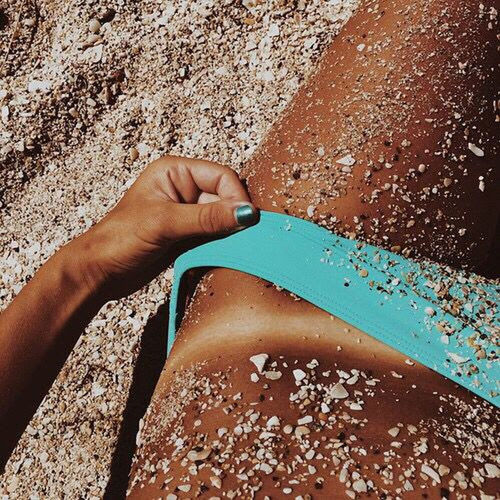 HIGH ANGLE VIEW OF WOMAN HAND ON SAND