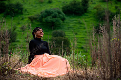 Portrait of young woman sitting in forest