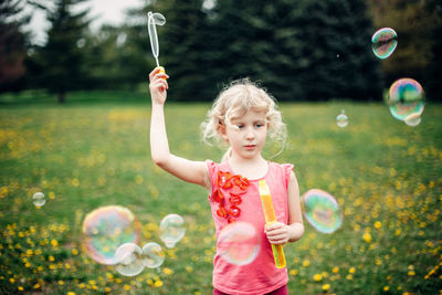 Full length of girl holding bubbles