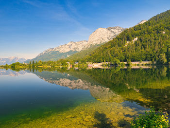 Scenic view of lake and mountains against blue sky