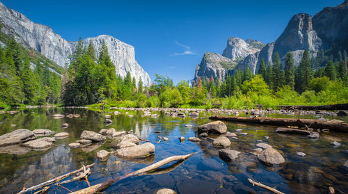 Scenic view of lake and mountains against blue sky