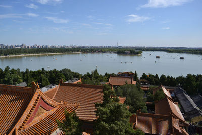 High angle view of buildings by lake against sky