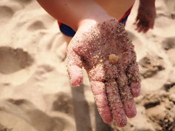 Close-up of hand on sand