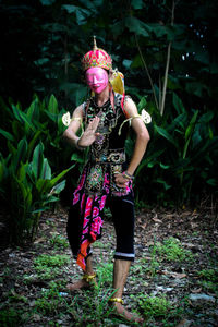 Full length of woman standing on field in forest