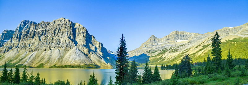 Panoramic view of lake and mountains against clear blue sky