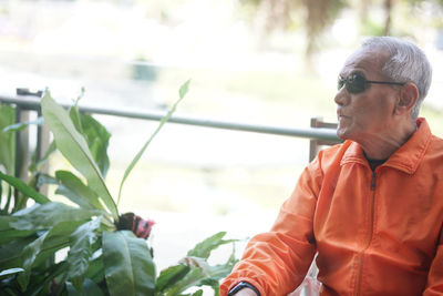 Portrait of young man standing against plants