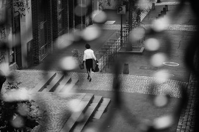 Rear view of people walking on street in city