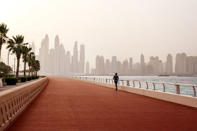 Rear view of man walking on buildings in city