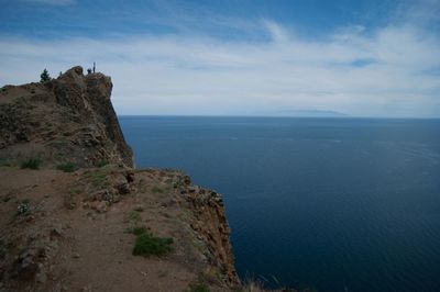 Scenic view of sea by cliff against sky