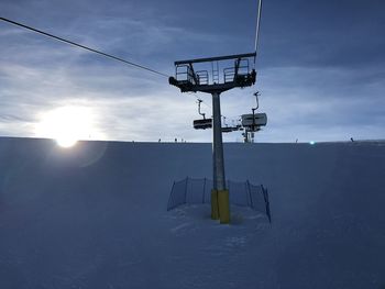 Low angle view of ski lift against sky during winter