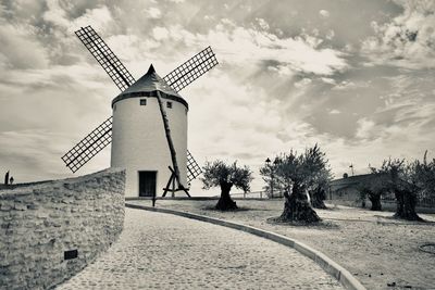 Traditional windmill on landscape against sky