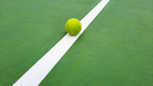 Tennis ball on a line of tennis court 