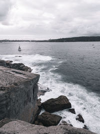 Rocks by sea against sky