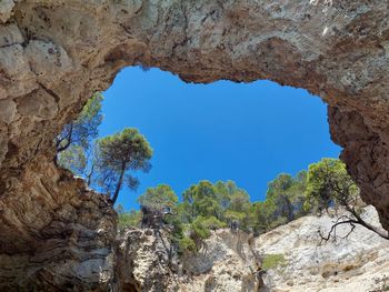 Low angle view of rock formation against clear blue sky