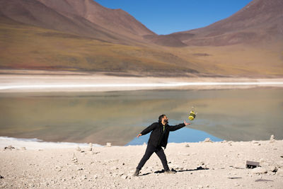 Full length of man standing on shore against sky