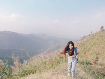 Happy asian young woman walking trail in mountain with amazing view.